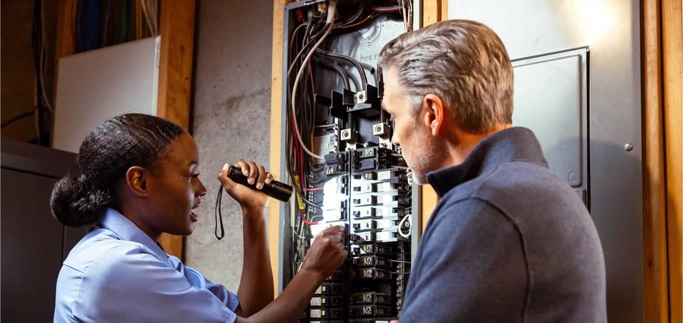 Pro helping homeowner with electrical panel